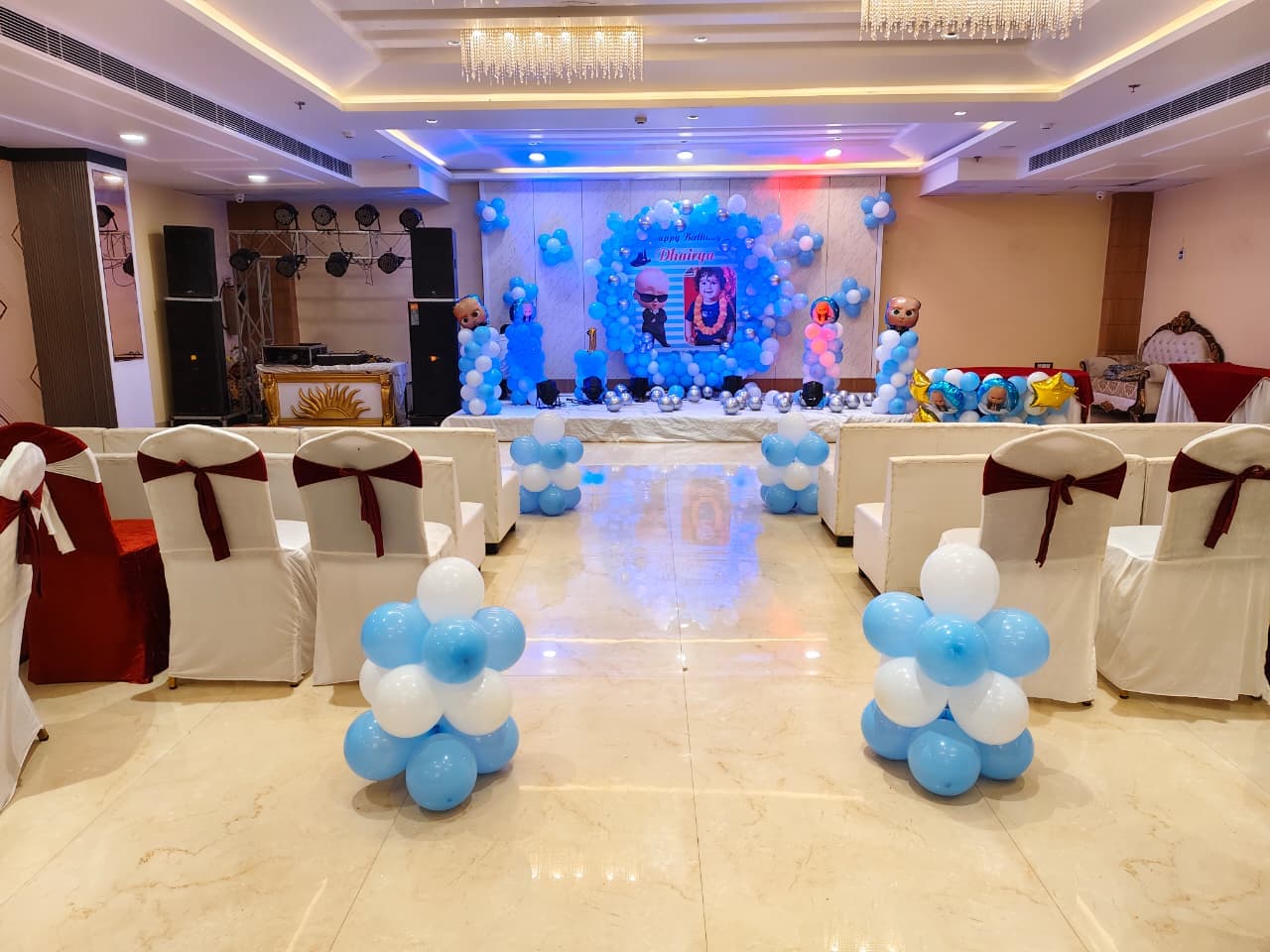 Boss Baby themed birthday party with blue and white balloons in a banquet hall.